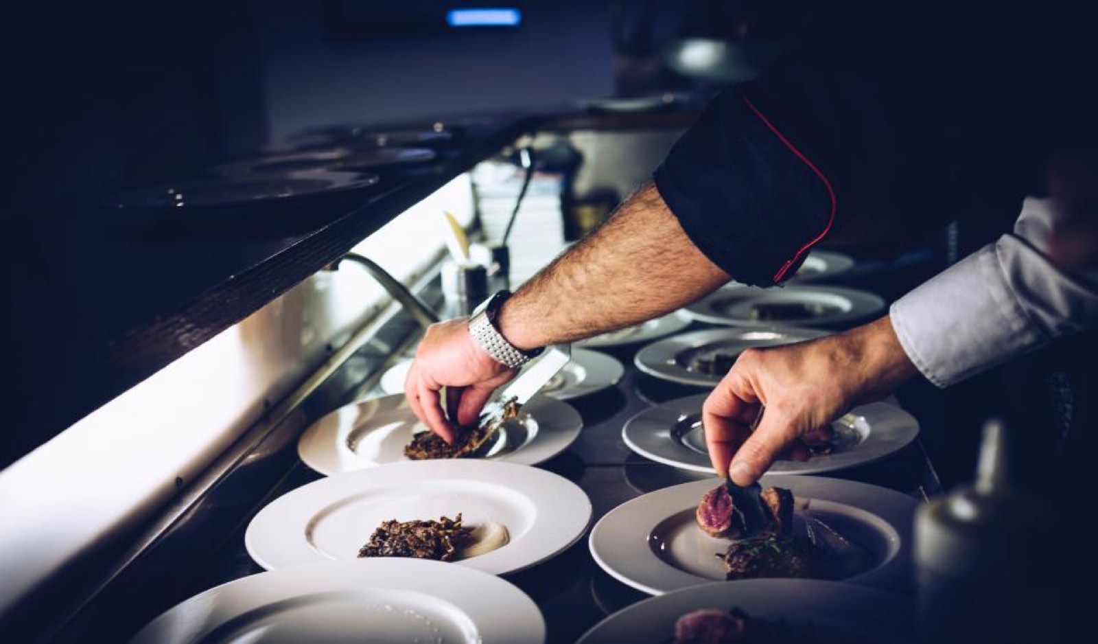 A chef plating food in a kitchen