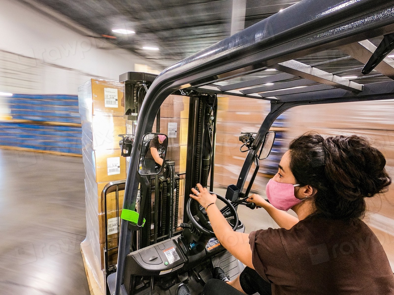 A woman driving a forklift in a warehouse