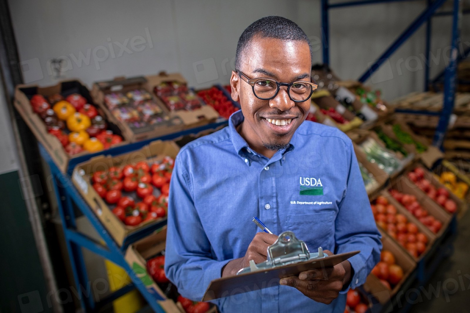 A smiling grocer with a tablet among fresh produce