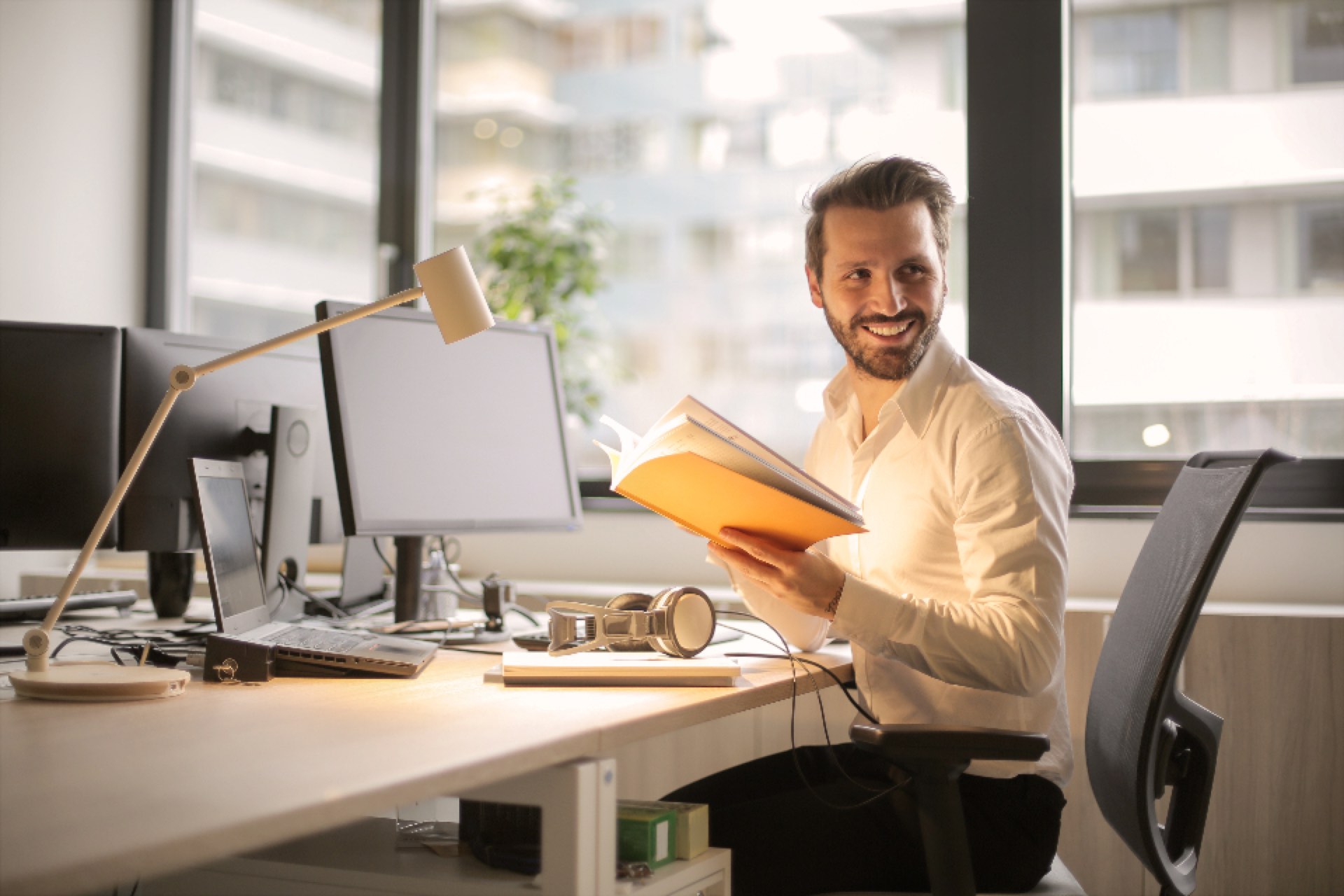 A smiling man at his desk in a bright office