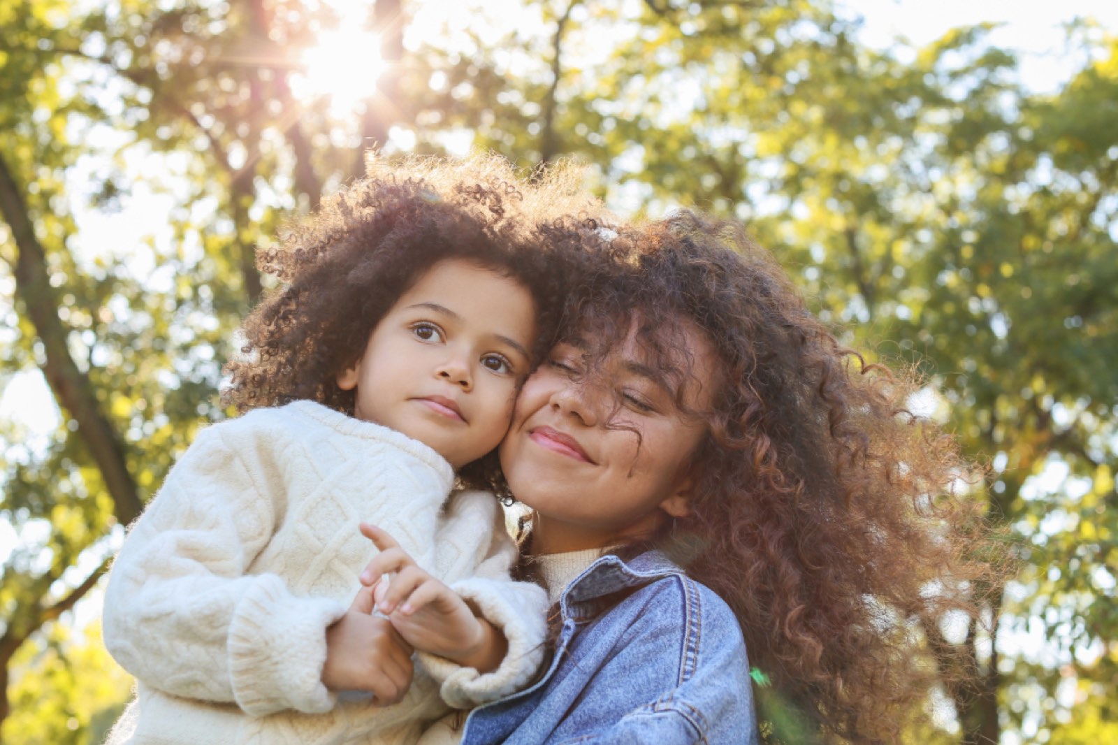 A mother hugging her child outdoors