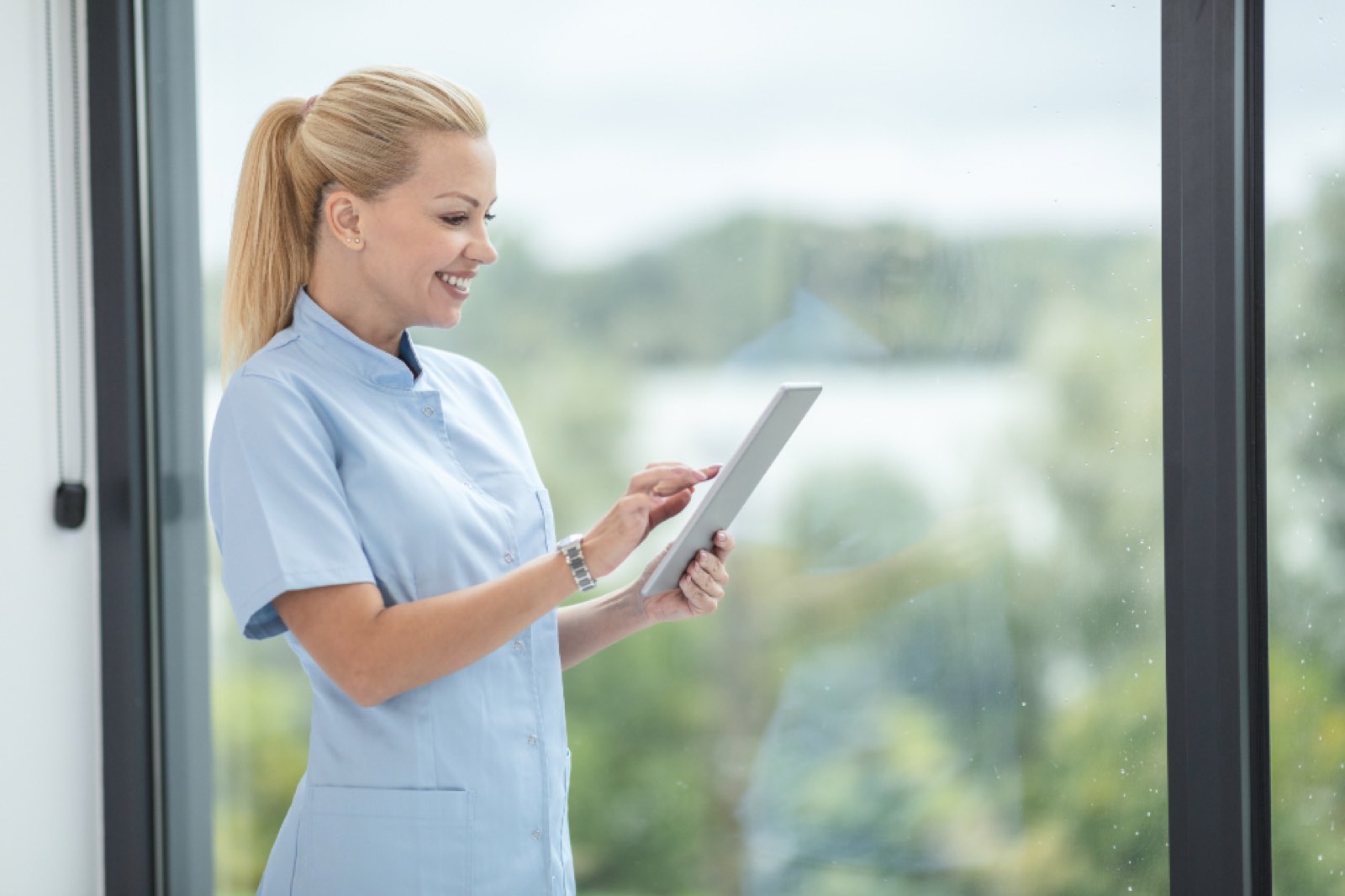 A smiling nurse with a tablet