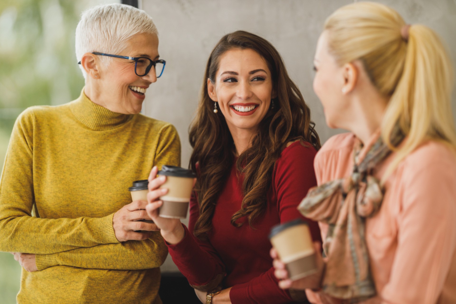 Colleagues laughing together over coffee at work